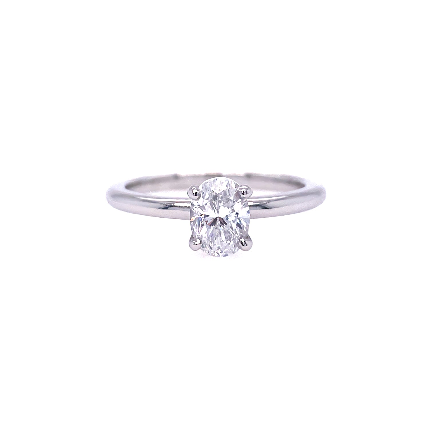 An oval solitaire diamond ring with a clear, central diamond surrounded by a plain  polished platinum band.