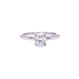 An oval solitaire diamond ring with a clear, central diamond surrounded by a plain  polished platinum band.
