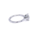 A platinum diamond ring with an oval brilliant-cut center diamond in a double fang four-prong setting, shown from a side profile view on a plain white background.