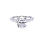 A classic solitaire engagement ring featuring an oval brilliant-cut diamond set in a polished platinum band, shown against a plain white background.