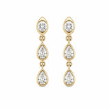 A pair of 14K gold dangle earrings with three bezel set diamonds in each earring, on a plain white background.