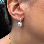 Close-up of an ear wearing a pearl and diamond earring.