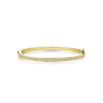 Gold bracelet with small box-set diamonds on a white background