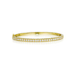 An 18K yellow gold bangle bracelet with Pave diamonds set around its circumference.