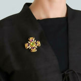 Peridot brooch with Amethysts and Tourmaline on a black garment 