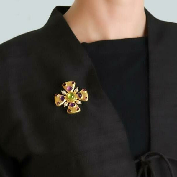 Peridot brooch with Amethysts and Tourmaline on a black garment 