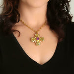 19K Gold necklace with a cross pendant featuring purple amethysts and green peridots designed by Elizabeth Locke