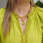 Woman wearing a 19K gold necklace with a Peridot pendant designed by Elizabeth Locke