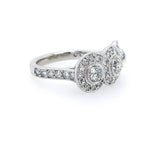 A platinum diamond ring with a three-stone cluster setting and pavé band, photographed on a clean white background.