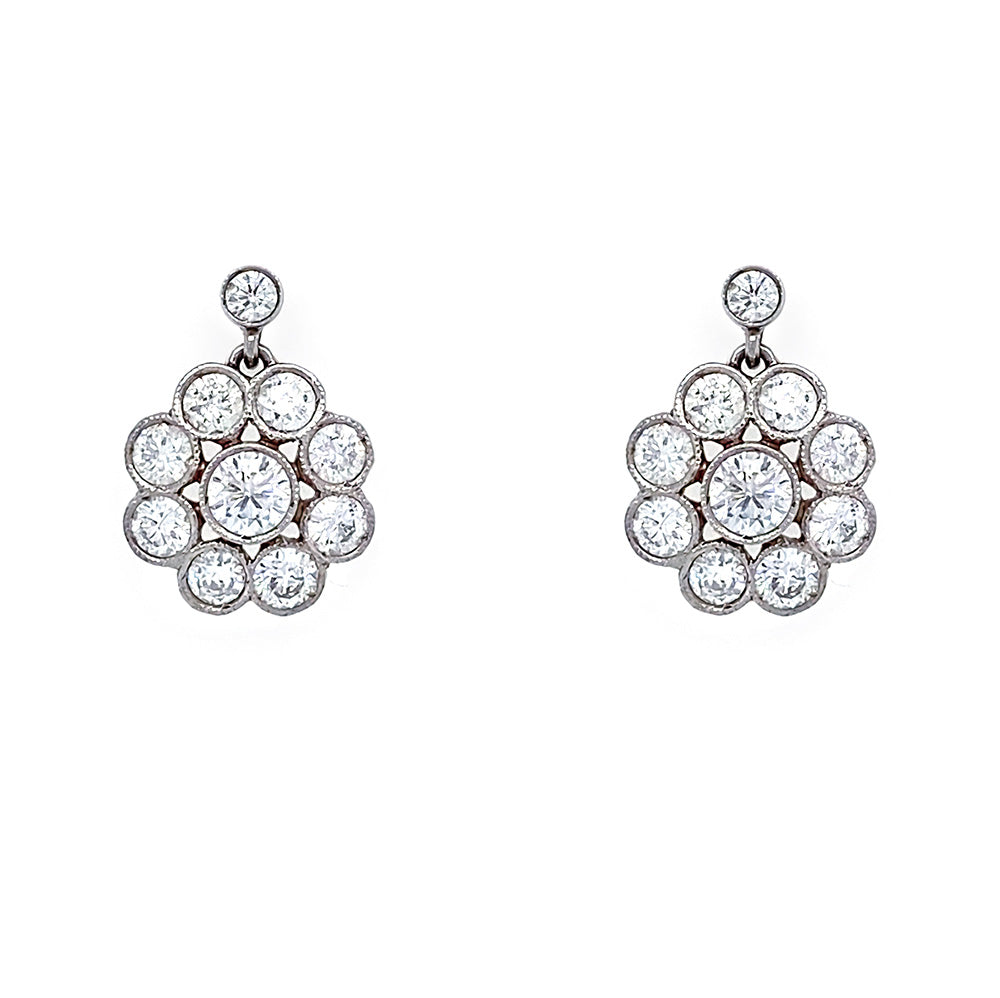 A pair of platinum cluster earrings featuring multiple round-cut clear diamonds arranged in a floral or sunburst pattern, shown on a plain white background.