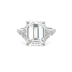 Diamond ring with emerald-cut center stone on a white background