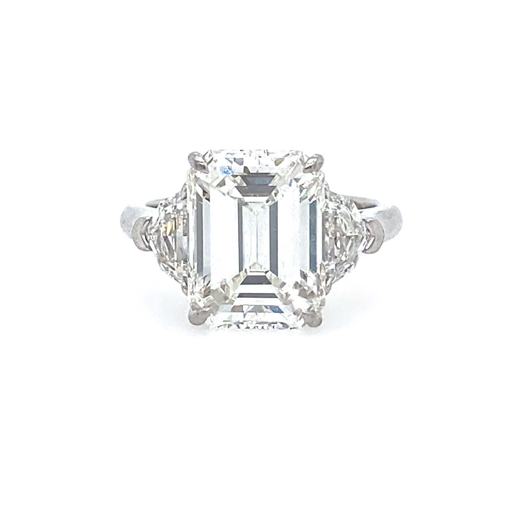 Diamond ring with emerald-cut center stone on a white background