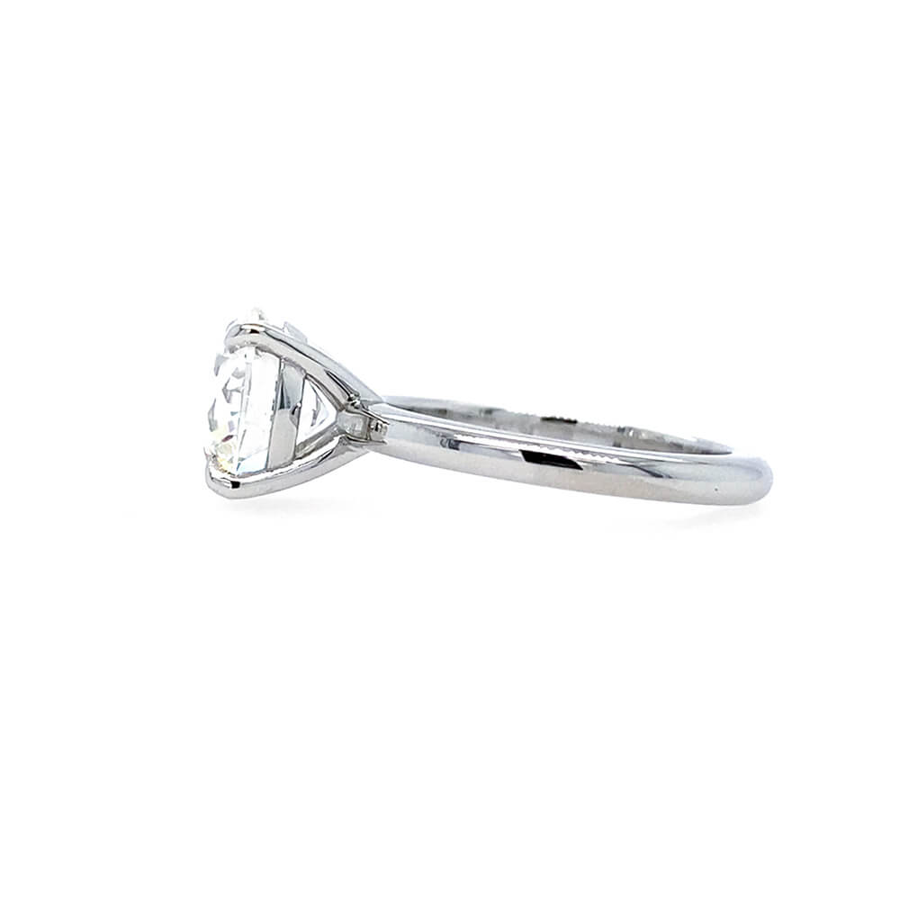 side view of round brilliant cut diamond solitaire engagement ring with 4 prong setting and plain polished shank in platinum