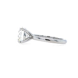 side view of round brilliant cut diamond solitaire engagement ring with 4 prong setting and plain polished shank in platinum