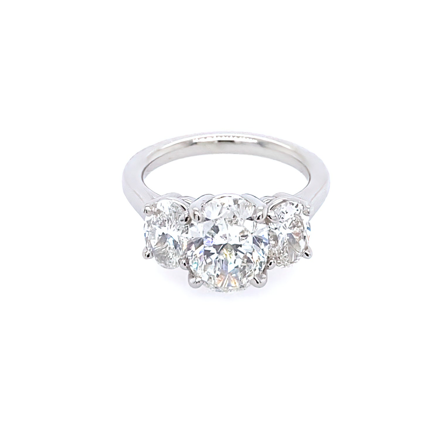This image features an exquisite Platinum and Diamond Three Oval Diamond Ring. The ring showcases a stunning trio of oval-shaped diamonds, each beautifully set in a platinum band.