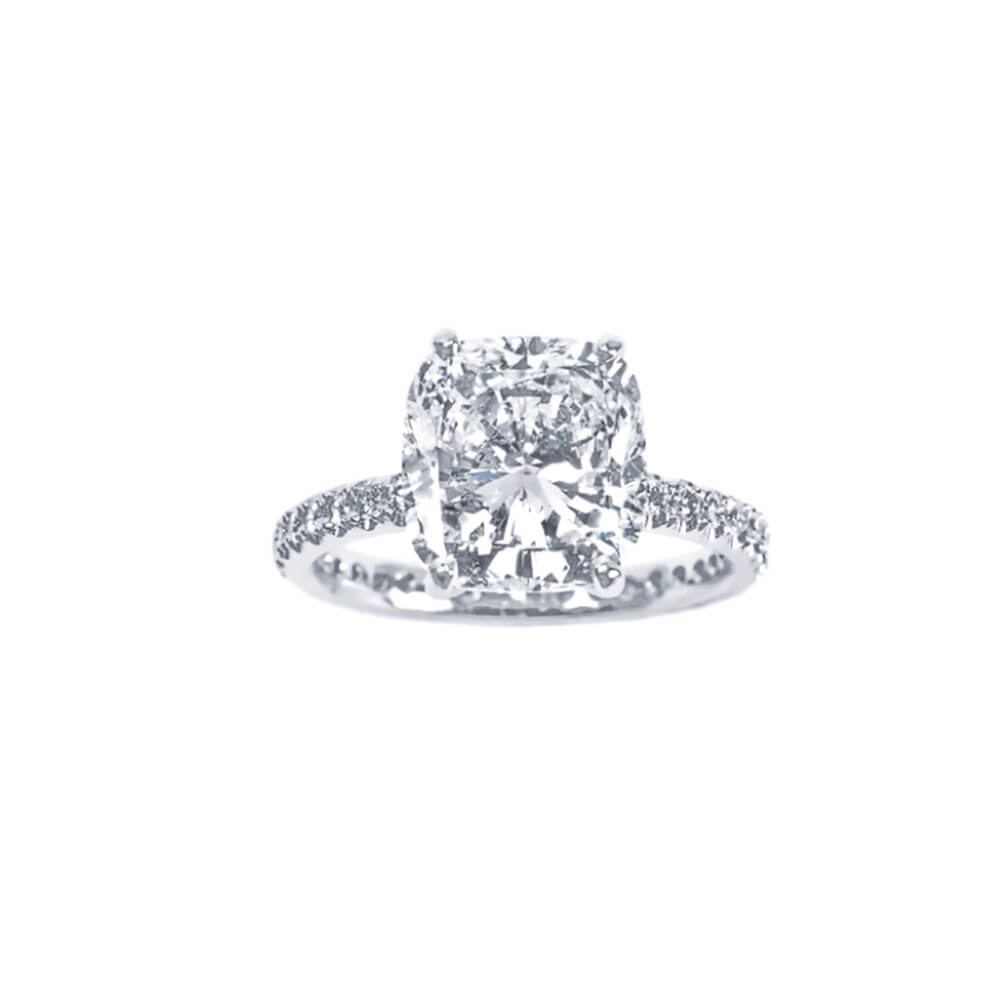 Diamond ring with a large central gemstone and smaller stones on the band against a white background