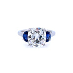 A platinum cushion cut diamond ring with half moon sapphire sides