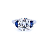 A platinum cushion cut diamond ring with half moon sapphire sides