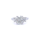 A platinum cushion cut diamond ring with step-cut trapezoid side stones