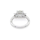 A platinum diamond ring with a round center stone and trapezoid side stones, shown from a inside view on a white background.