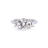 A platinum band ring with a central diamond and smaller diamonds set around it.