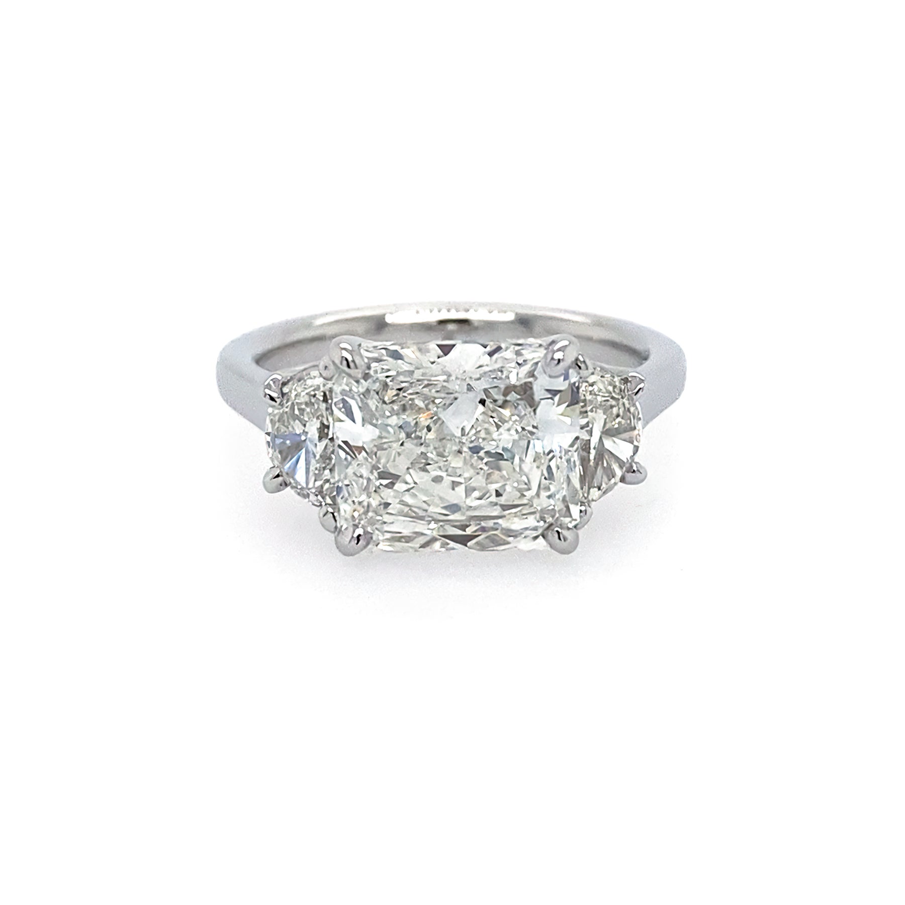 A platinum ring with a radiant cut design, featuring a central diamond surrounded by half moon shaped diamonds