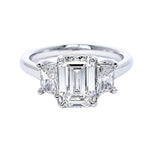 Custom Platinum engagement ring with emerald-cut center diamond on a white background