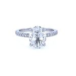 A platinum band ring with a central oval-shaped diamond and smaller diamonds around the band.