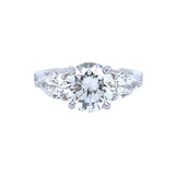 A platinum round diamond ring with a pear shaped side stone.