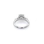 A platinum diamond engagement ring with a round brilliant center stone and side tapered baguette stones, shown on a plain white background.