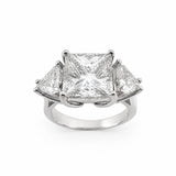 A three-stone diamond ring featuring a central princess-cut diamond flanked by two smaller trillion-cut diamonds in a platinum setting, shown on a plain white background.