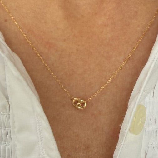 woman wearing a yellow gold dainty necklace