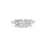 A three-stone diamond ring featuring rectangular radiant-cut diamonds set in a platinum band, centered on a plain white background.