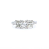 A three-stone diamond ring featuring rectangular radiant-cut diamonds set in a platinum band, centered on a plain white background.