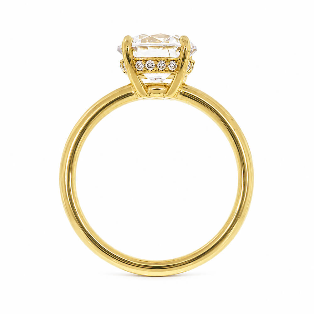 An 18K yellow gold ring with a large clear round-cut center diamond and a hidden halo of small clear diamonds shown against a plain white background.