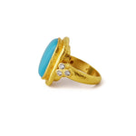 A 19K yellow gold ring featuring a large turquoise stone in a hammered gold bezel setting, accented with three small clear diamonds on the band, shown against a plain white background.
