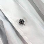 Sterling Silver knot-shaped stud on a white shirt