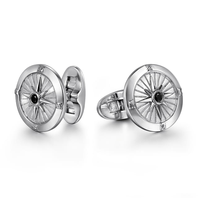 Silver cufflinks with intricate design on a white background