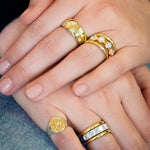 Woman wearing several 18K gold and diamond rings designed by Laura Pearce