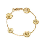 An 18K yellow gold bracelet with several circular charms featuring diamond accents, connected by a gold chain.