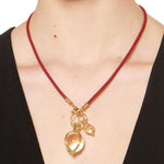 Woman wearing Temple St Clair Round Rock Amulets on a red cord necklace