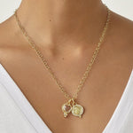 A gold chain necklace with two 18K yellow gold pendants designed by Temple St. Clair..  