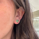 Close-up of an ear wearing Temple St Clair 18K gold emerald and diamond stud earrings