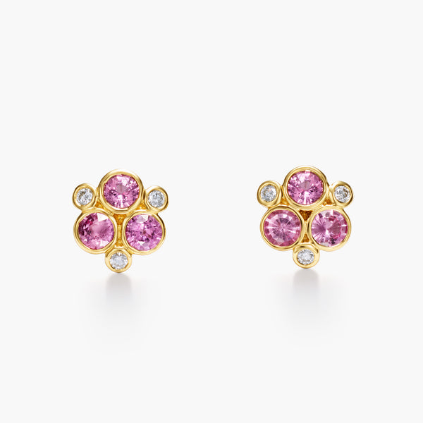 A pair of 18K yellow gold stud earrings featuring pink sapphire centers surrounded by white diamond accents