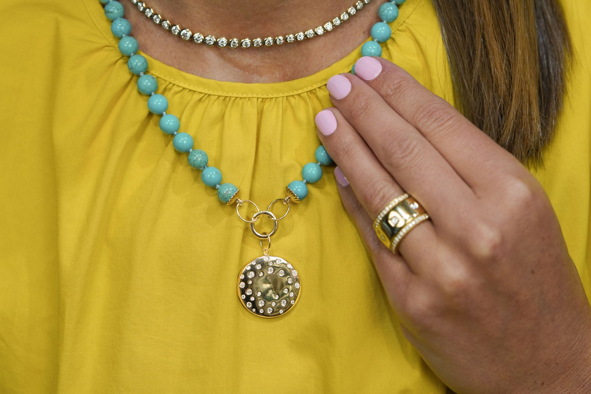 Turquoise beaded necklace with a pendant and 14K yellow gold clasp.