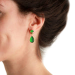 Close-up of a woman wearing green Venetian Glass Intaglio teardrop earrings on a white background