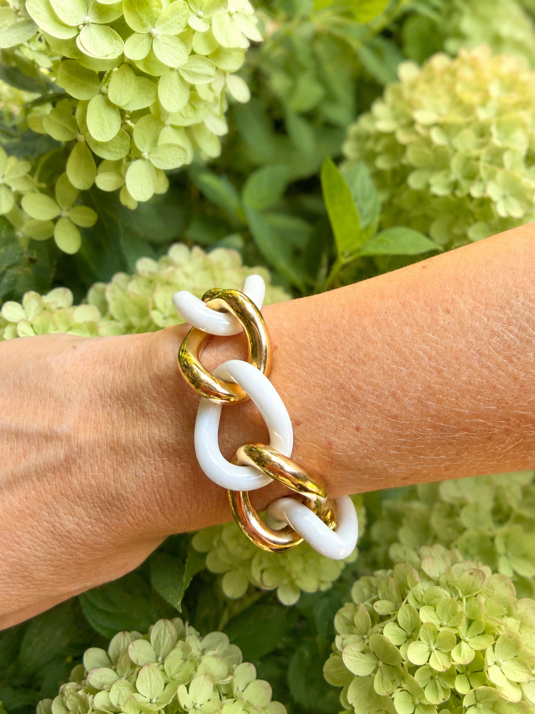 woman's wrist wearing a white agate and gold link bracelet 
