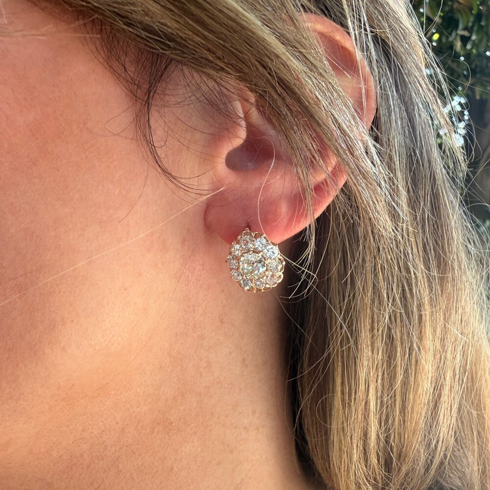 A close-up of a woman's ear wearing an Estate 14K rose gold diamond cluster stud earring 