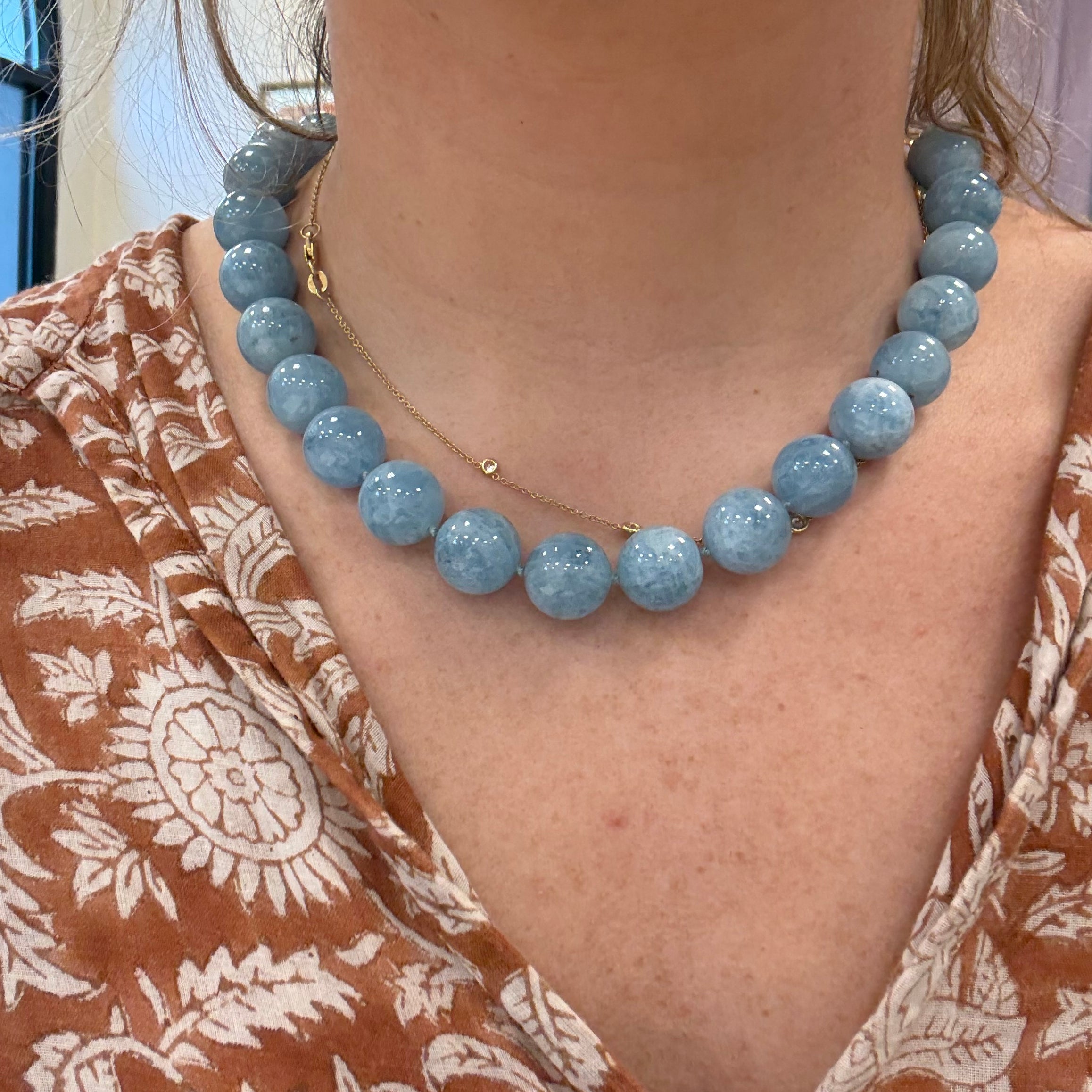 aquamarine blue beaded necklace on person