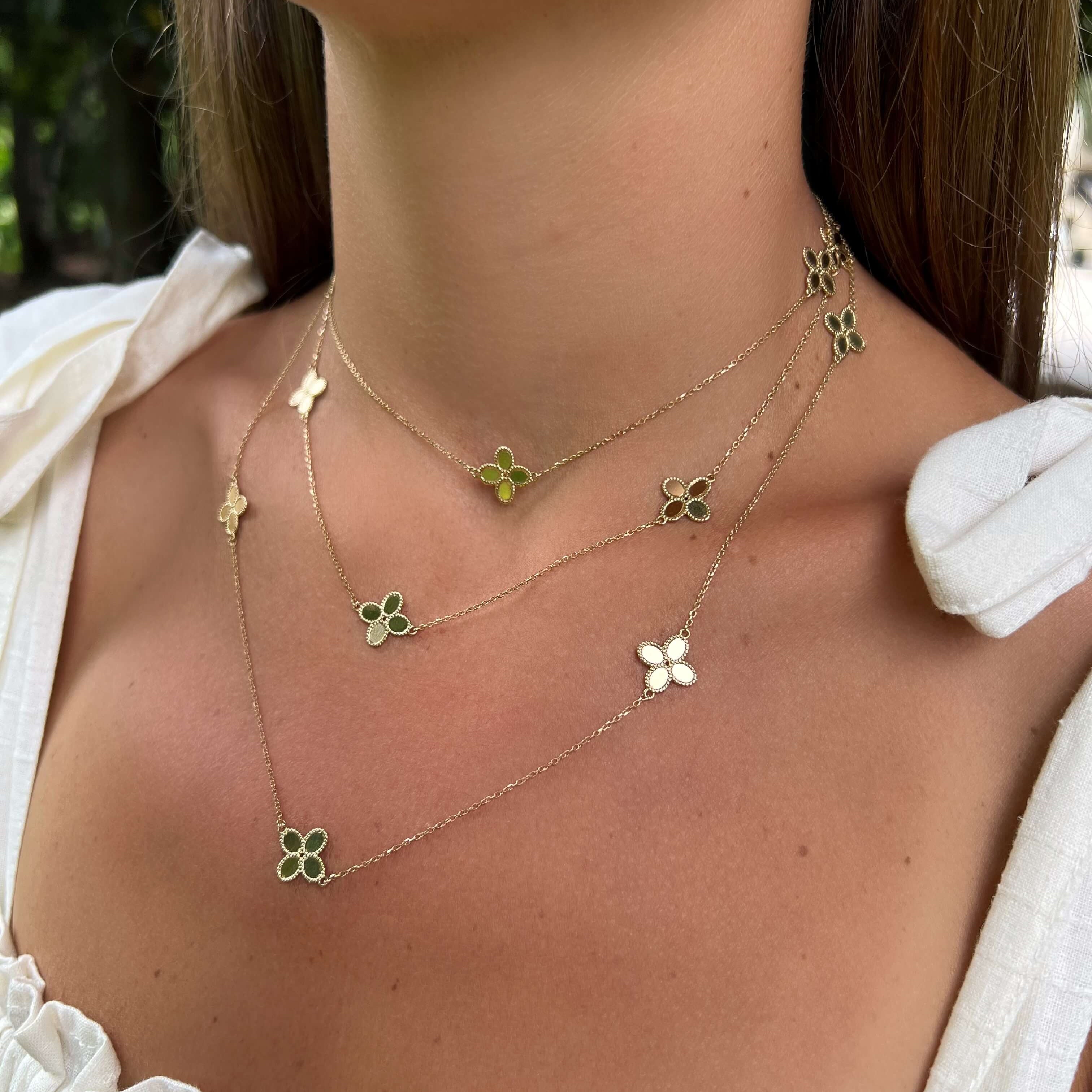 Woman wearing three 14K Yellow Gold Clover Station Necklaces
